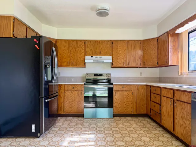 a kitchen with granite countertop a refrigerator and a sink