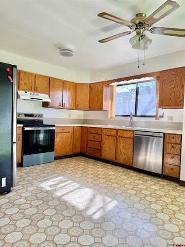 a kitchen with stainless steel appliances granite countertop a stove a sink and a refrigerator
