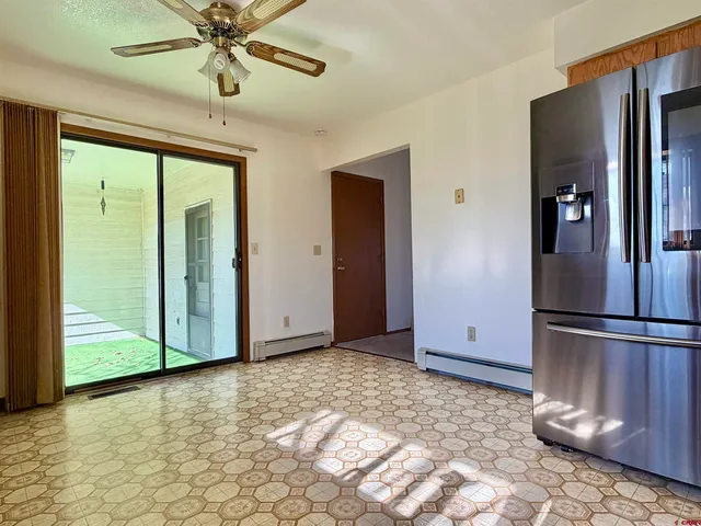 a view of a livingroom with a ceiling fan and kitchen space