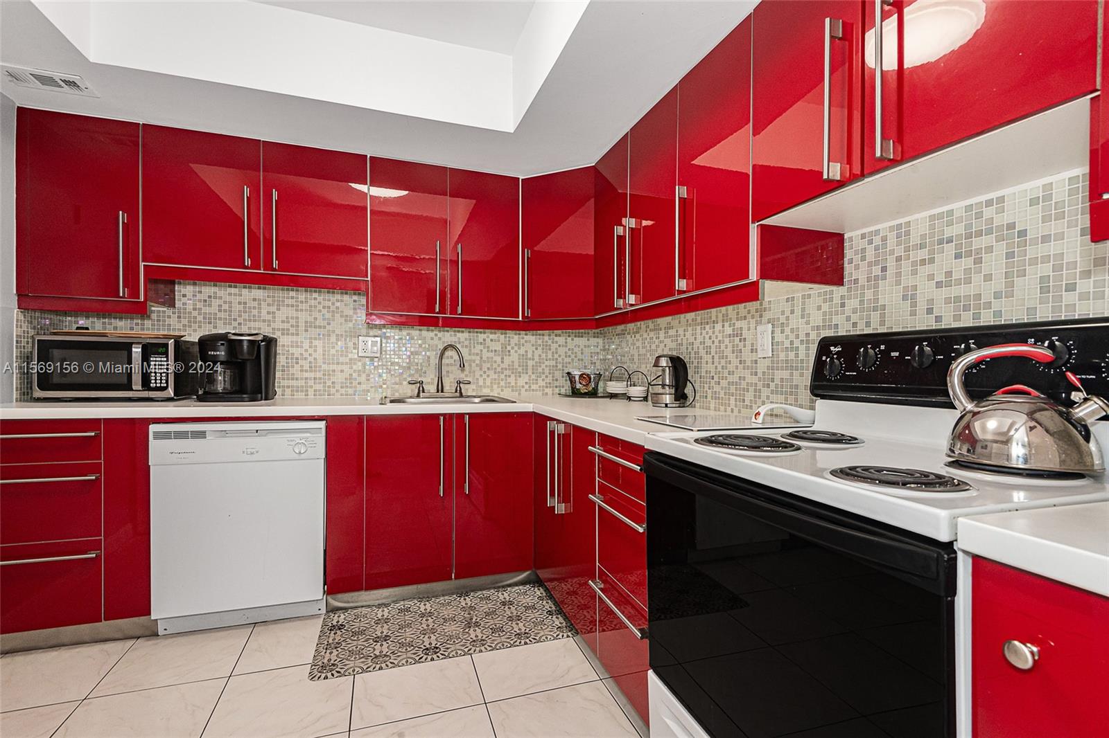 a kitchen with stainless steel appliances a sink dishwasher a stove and red cabinets
