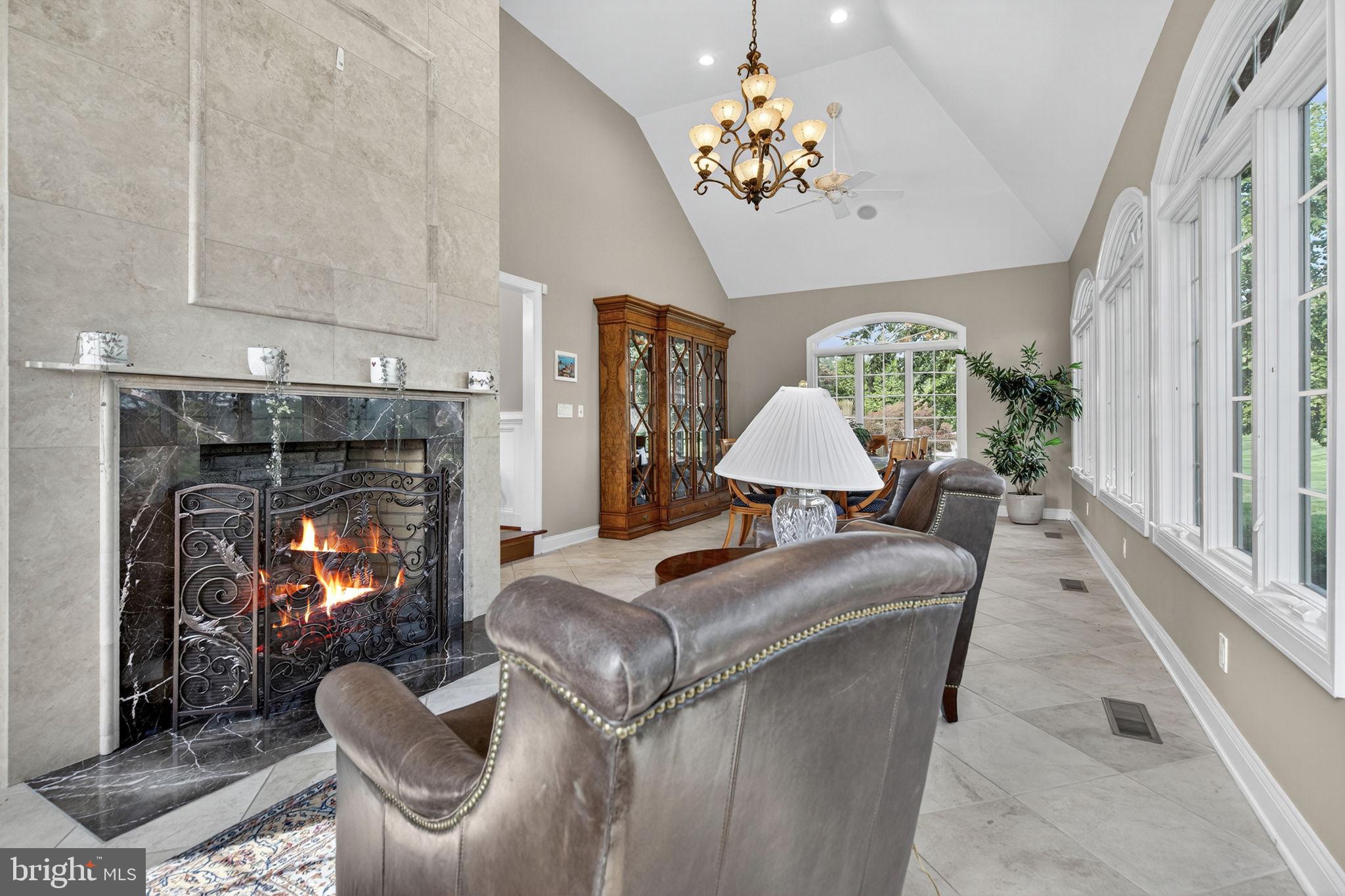 7484 Wilson Road Warrenton, VA 20186 - Photo 37 of 81 a living room with furniture a chandelier and a fireplace