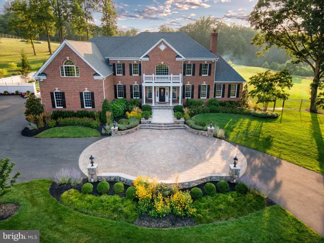 a front view of a house with a yard and potted plants