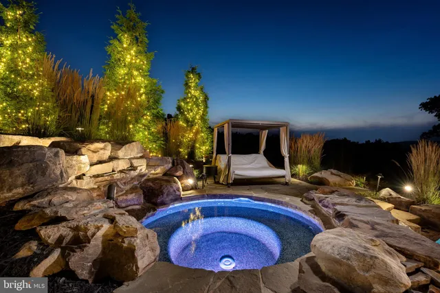 an aerial view of a house with a swimming pool and outdoor seating