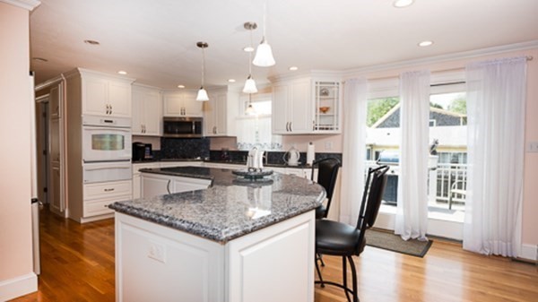 32 Columbus Road Marshfield, MA 02050 - Photo 15 of 37 a large kitchen with granite countertop a stove a sink a dining table and chairs