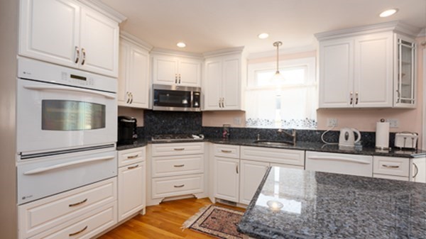 32 Columbus Road Marshfield, MA 02050 - Photo 16 of 37 a kitchen with granite countertop white cabinets and white appliances