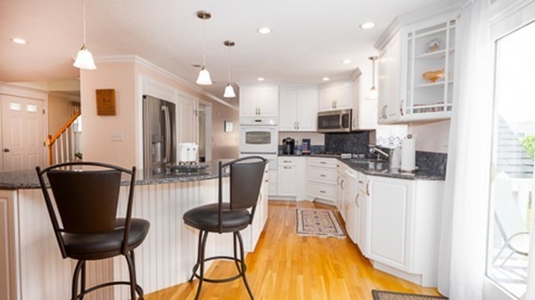 32 Columbus Road Marshfield, MA 02050 - Photo 17 of 37 a kitchen with stainless steel appliances refrigerator dining table and chairs