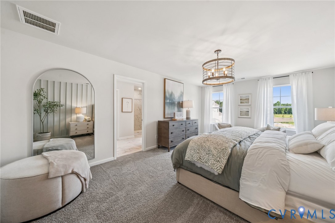 155 Liberty Lane Keswick, VA 22947 - Photo 14 of 32 a spacious bedroom with a bed and a chandelier