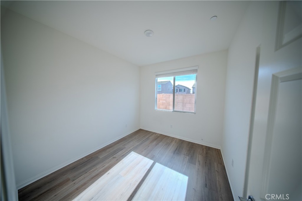 558 Pablo Road Lake Elsinore, CA 92530 - Photo 14 of 20 an empty room with wooden floor and windows