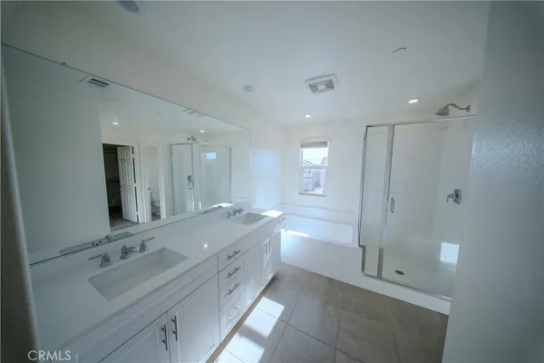 a bathroom with a double vanity sink mirror and shower