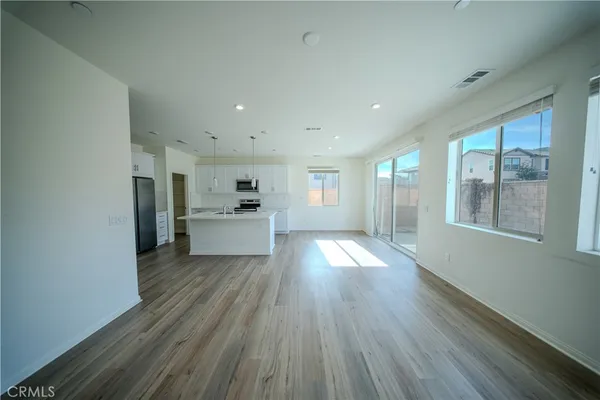 a view of a kitchen with furniture and wooden floor