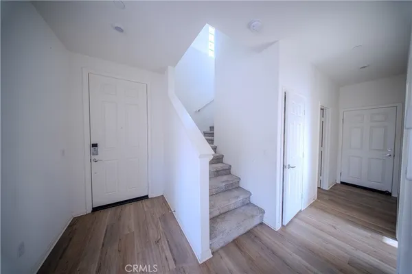 a view of a hallway with wooden floor and entryway
