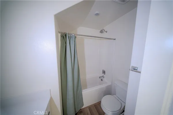 a bathroom with a granite countertop bathtub shower and toilet