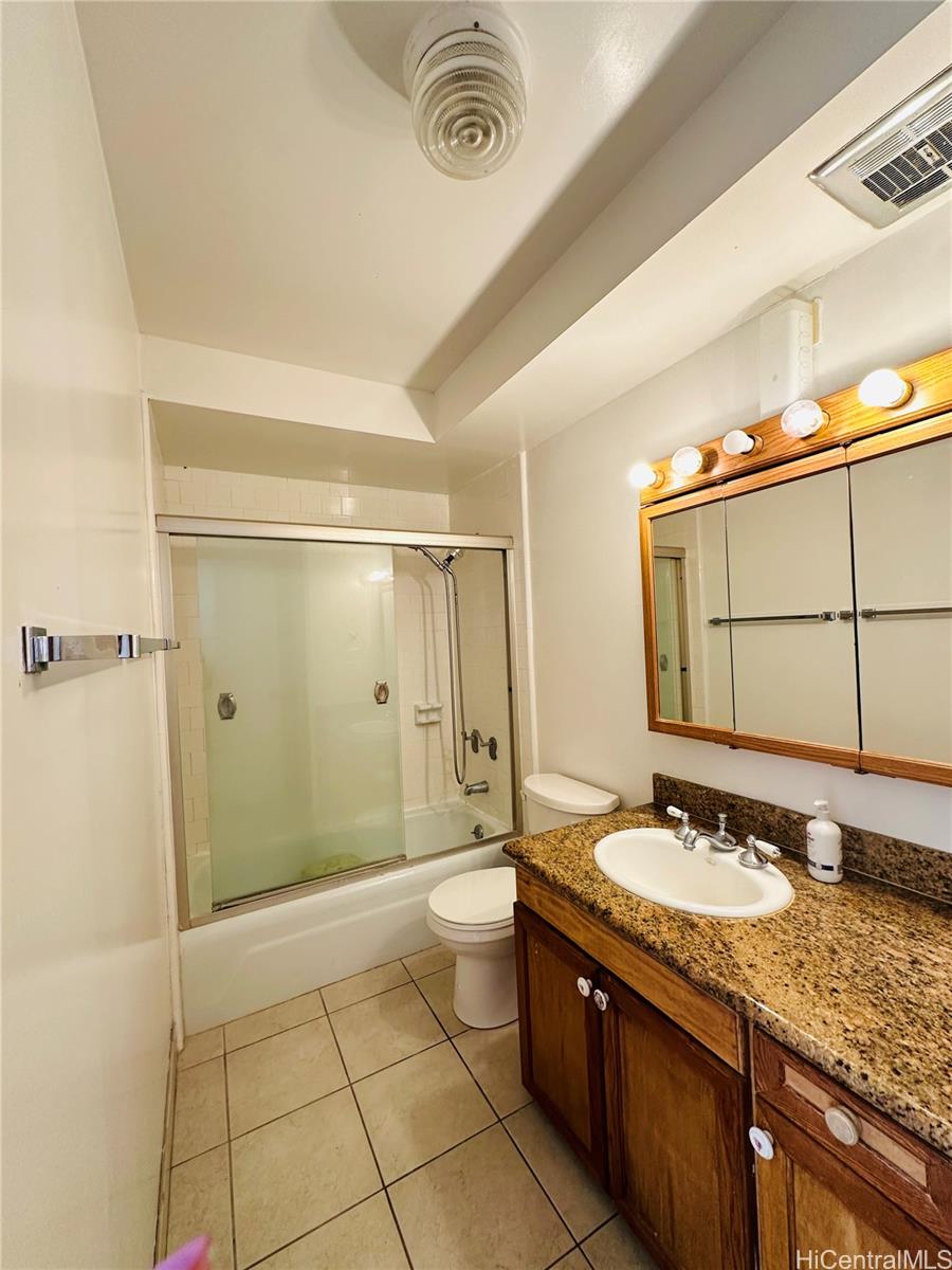 1019 Maunaihi Place, Unit 203 Honolulu, HI 96822 - Photo 8 of 19 a bathroom with a granite countertop sink a mirror and a shower