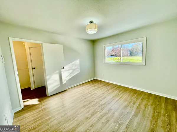 a view of empty room with wooden floor