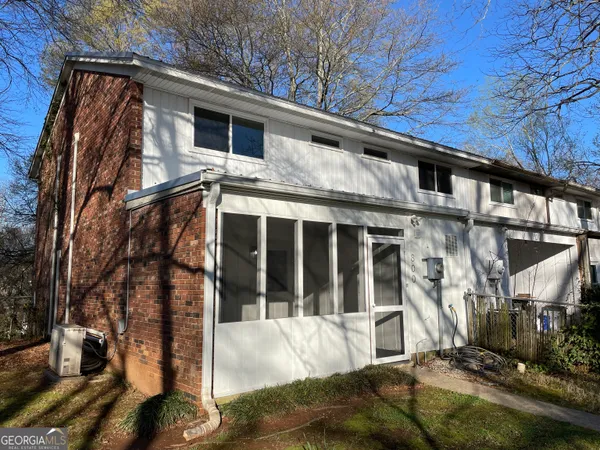 a view of a house with a large window and wooden fence