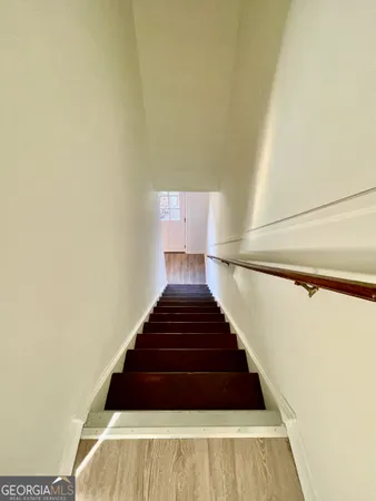 a view of a hallway with wooden floor and a cabinet
