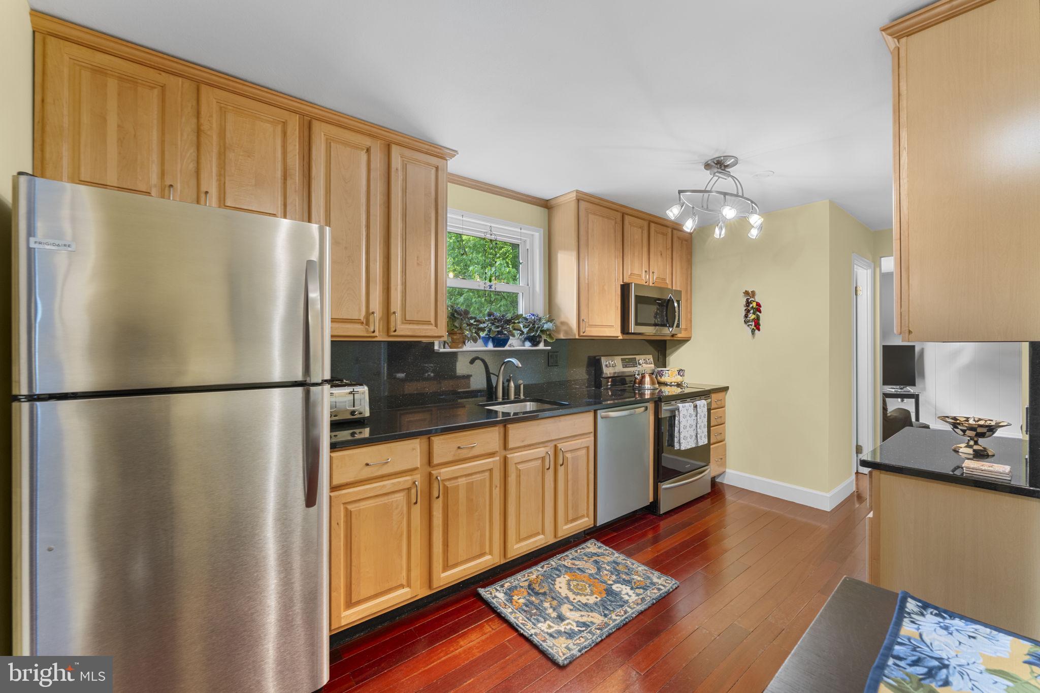 9801 Pulham Road Burke, VA 22015 - Photo 16 of 63 a kitchen with stainless steel appliances a refrigerator sink and wooden floor