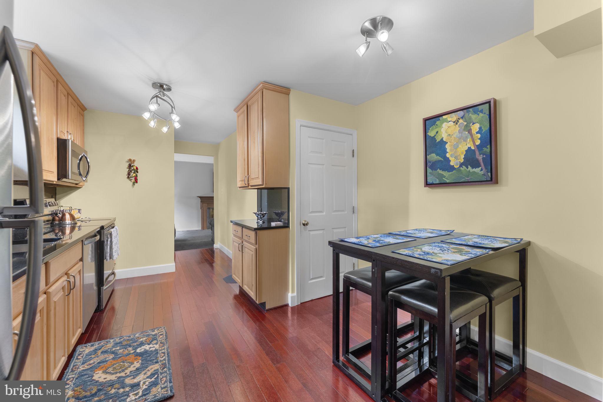 9801 Pulham Road Burke, VA 22015 - Photo 17 of 63 a kitchen with stainless steel appliances wooden floor and a refrigerator