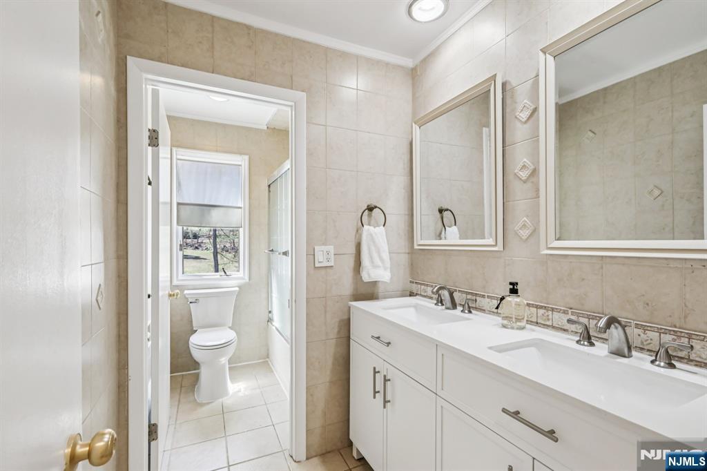 11 Carlough Road Upper Saddle River, NJ 07458 - Photo 32 of 41 a bathroom with a granite countertop sink toilet a shower and a mirror