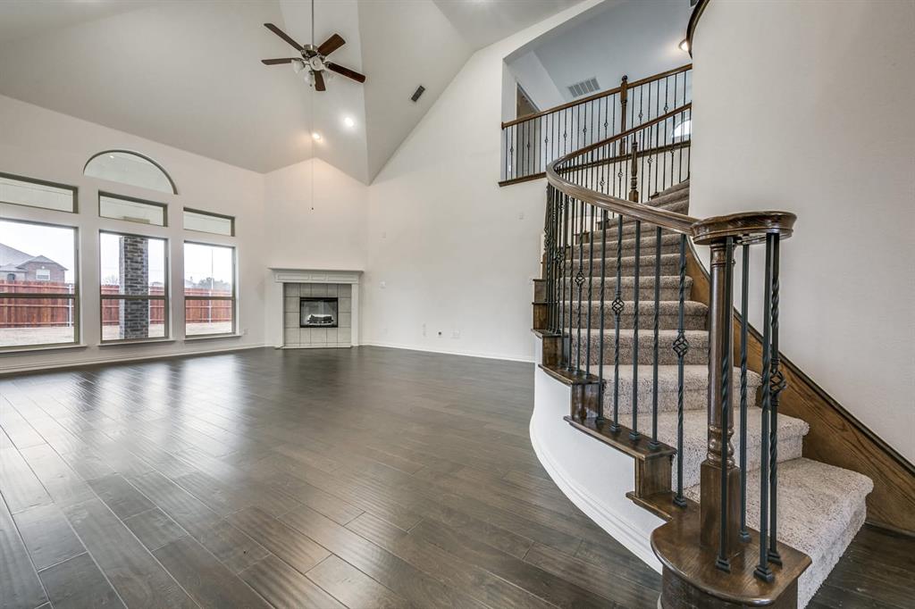 104 Sweetleaf Drive Red Oak, TX 75154 - Photo 12 of 36 Spacious living area featuring high vaulted ceilings, large windows providing natural light, and dark wood flooring