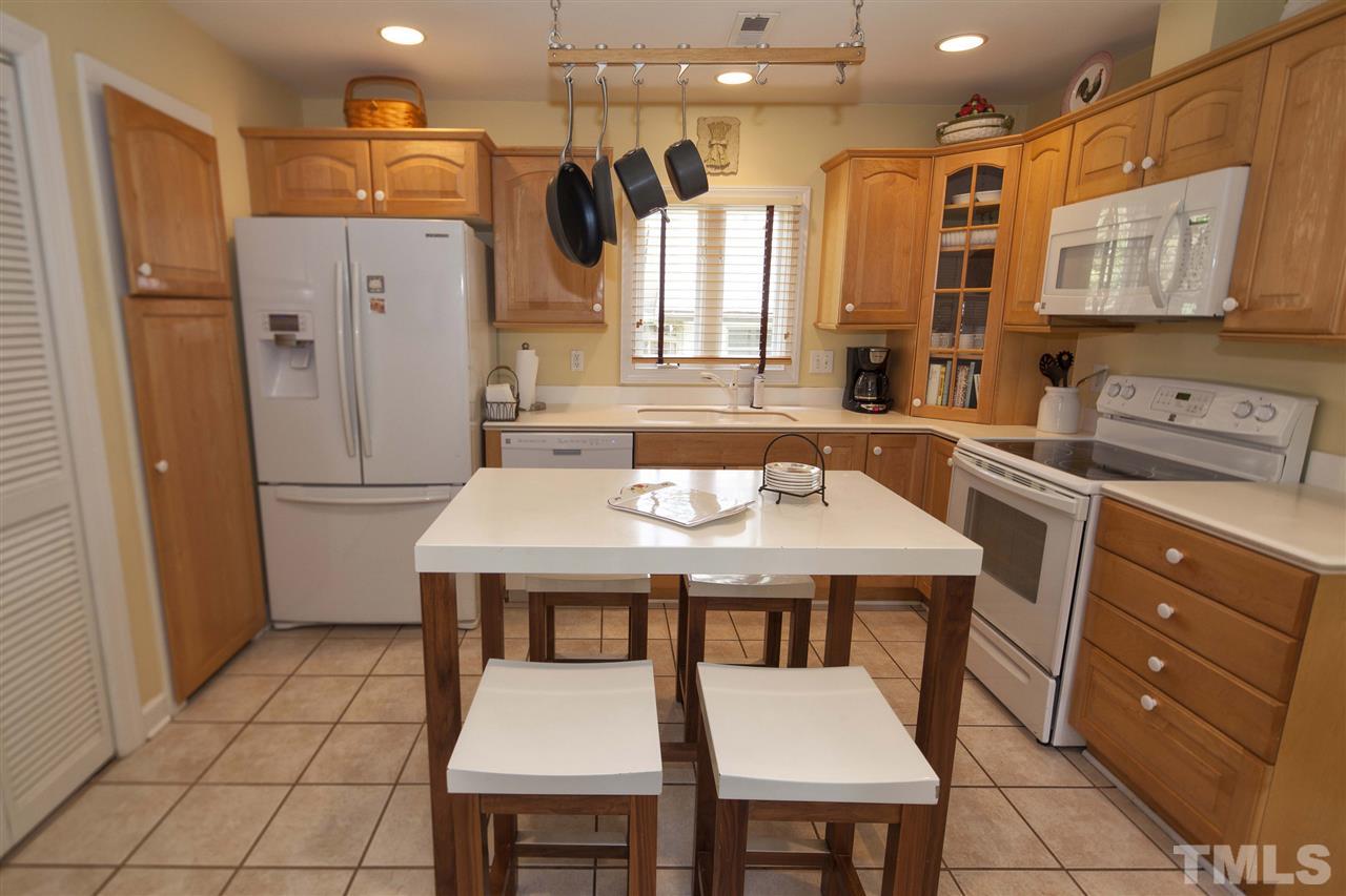 2609 Kittrell Drive Raleigh, NC 27608 - Photo 11 of 25 a kitchen with stainless steel appliances a table chairs and refrigerator