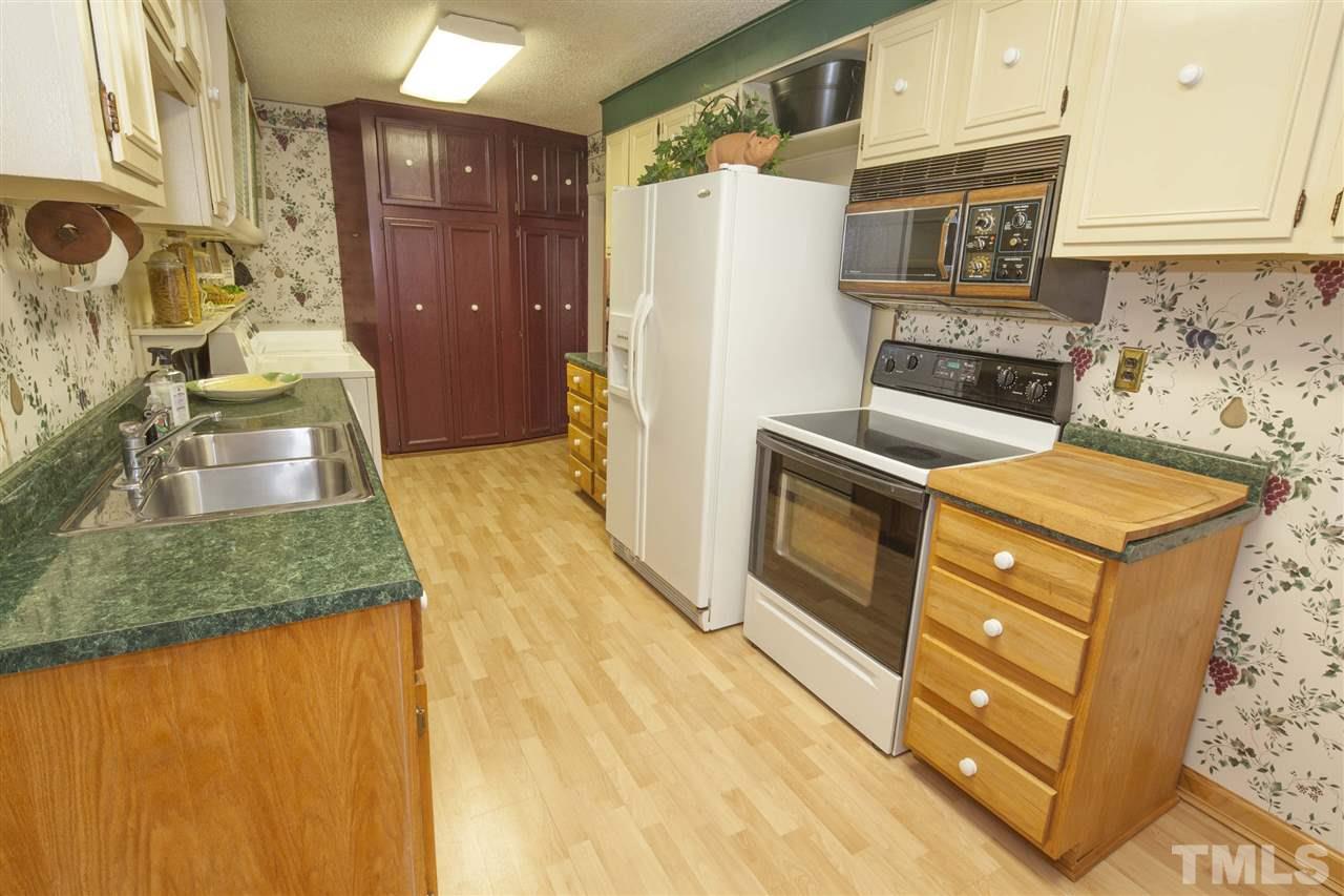 2609 Kittrell Drive Raleigh, NC 27608 - Photo 20 of 25 a kitchen with stainless steel appliances granite countertop a refrigerator a stove and a wooden cabinets