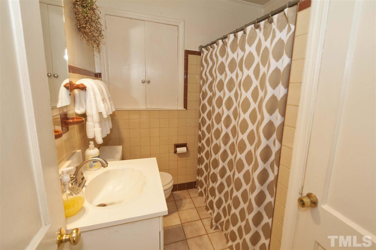 2609 Kittrell Drive Raleigh, NC 27608 - Photo 23 of 25 a bathroom with a sink and mirror with bathtub