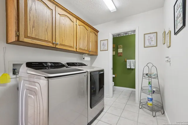 a utility room with fridge dryer and washer