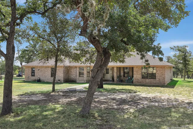 a view of a house with backyard and a tree