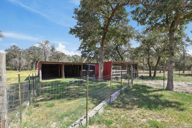 a backyard of a house with lots of green space and fountain