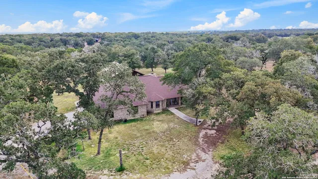 a aerial view of a house with table and chairs under an umbrella