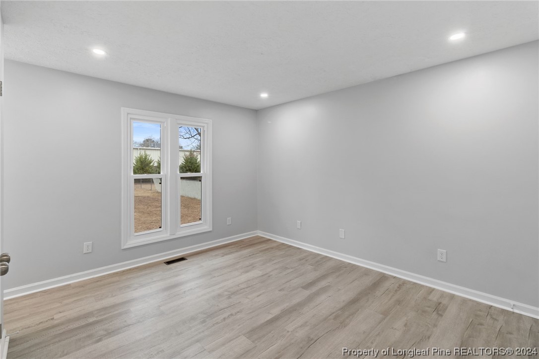 4108 Mill Bridge Road Hope Mills, NC 28348 - Photo 18 of 27 an empty room with wooden floor and windows