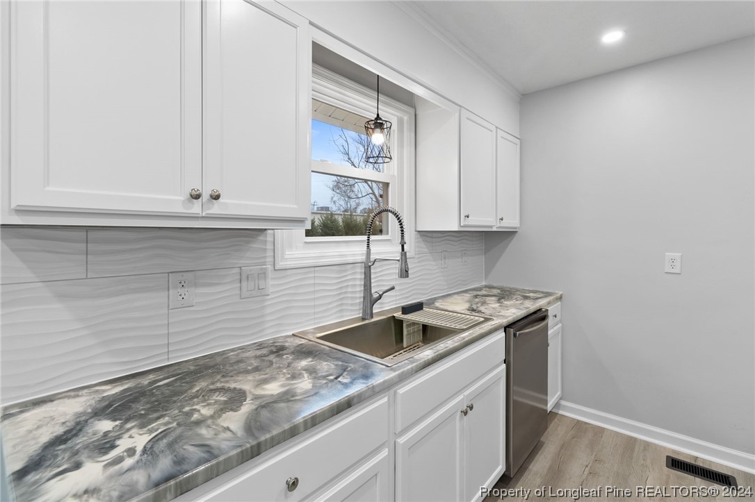 4108 Mill Bridge Road Hope Mills, NC 28348 - Photo 10 of 27 a kitchen with granite countertop white cabinets and a sink