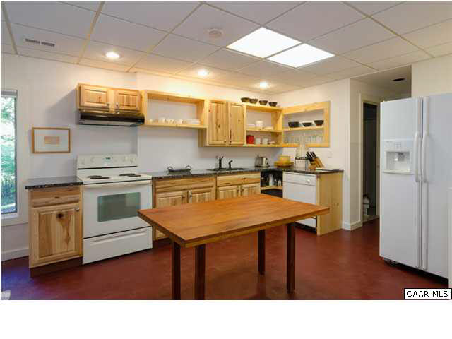 716 Wolf Trap Road Charlottesville, VA 22911 - Photo 18 of 26 a kitchen with stainless steel appliances kitchen island granite countertop a refrigerator a stove a sink dishwasher and white cabinets with wooden floor