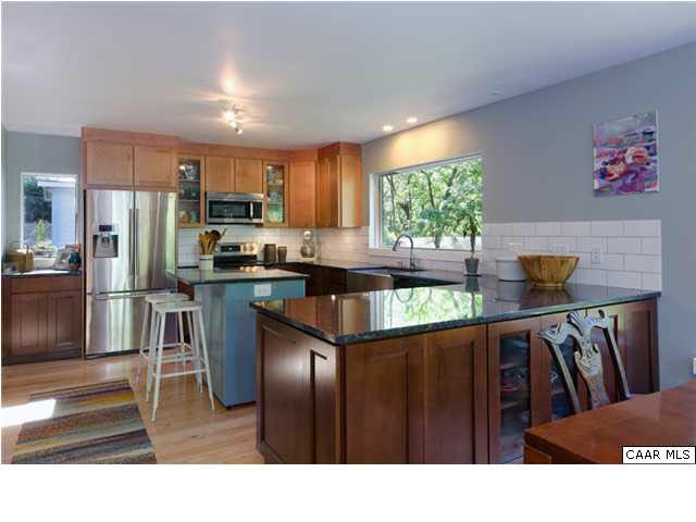 716 Wolf Trap Road Charlottesville, VA 22911 - Photo 5 of 26 a kitchen with stainless steel appliances kitchen island granite countertop a refrigerator a stove a sink dishwasher and wooden cabinets with wooden floor