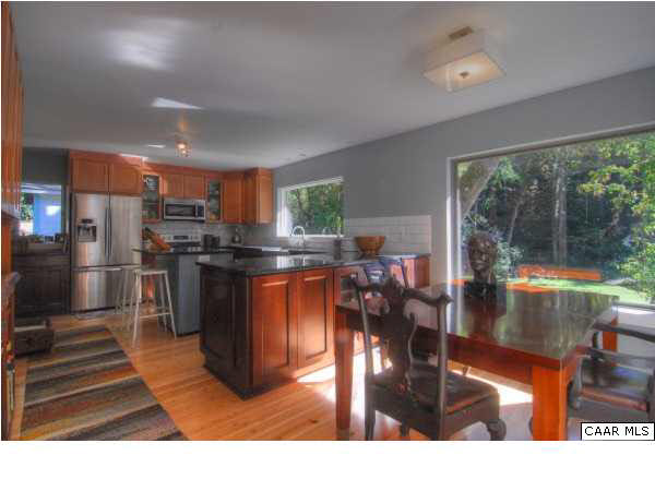 716 Wolf Trap Road Charlottesville, VA 22911 - Photo 8 of 26 a kitchen with stainless steel appliances granite countertop a refrigerator a stove top oven a dining table and chairs with wooden floor