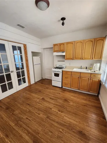 a view of kitchen with wooden floor and electronic appliances