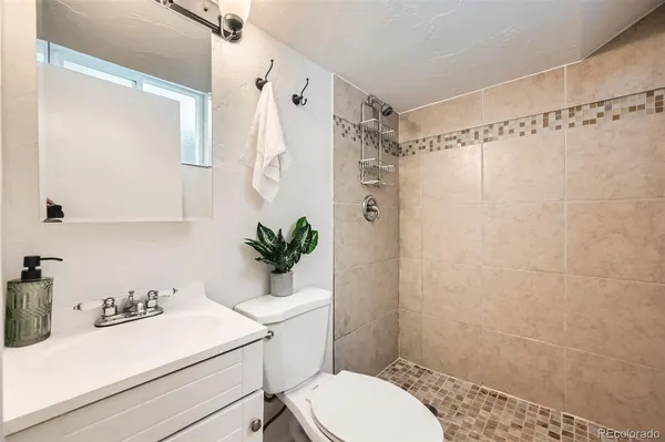 a bathroom with a sink a toilet a shower curtain and a mirror