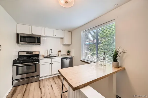 a kitchen with stainless steel appliances a stove a sink a microwave and cabinets