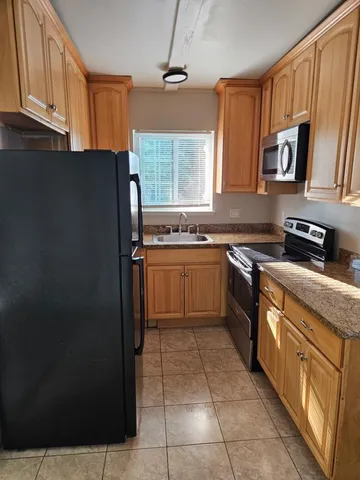 a kitchen with stainless steel appliances granite countertop a refrigerator sink and cabinets
