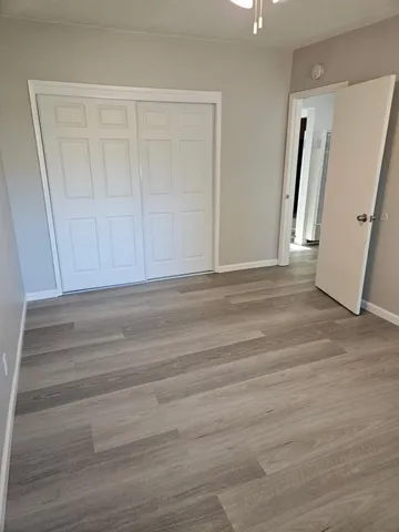 an empty room with wooden floor and mirror