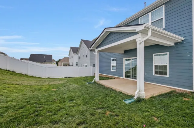 a view of a house with a yard and porch