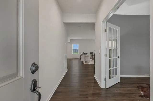 a view of a hallway with wooden floor and livingroom