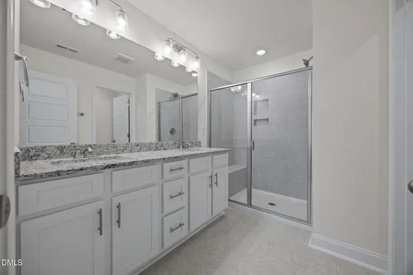 a bathroom with double sink and a shower