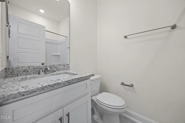 a bathroom with a granite countertop sink toilet and a mirror