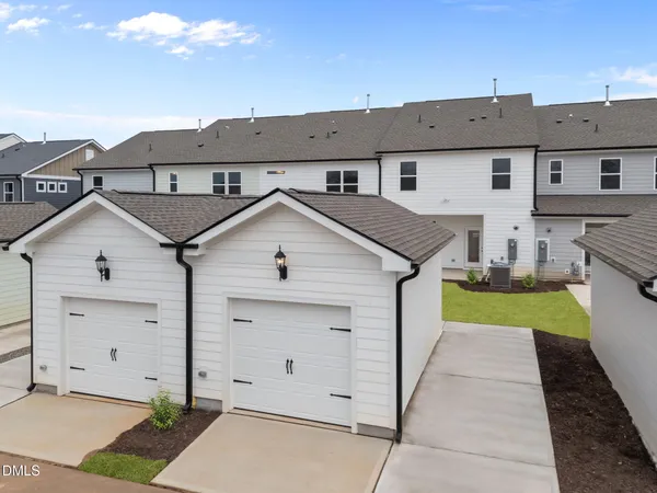 a view of a white house next to a yard
