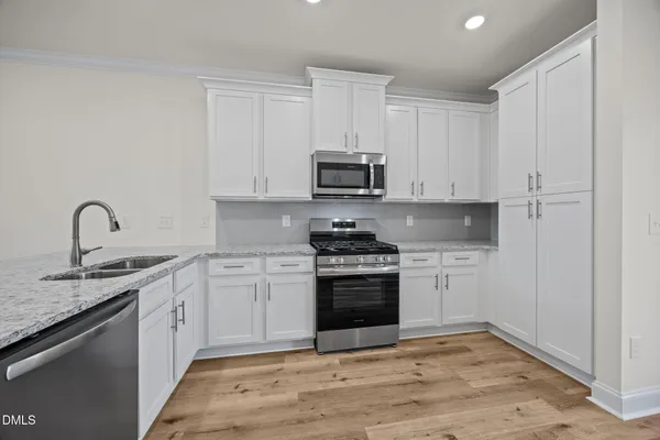 a kitchen with granite countertop a sink and a stove top oven