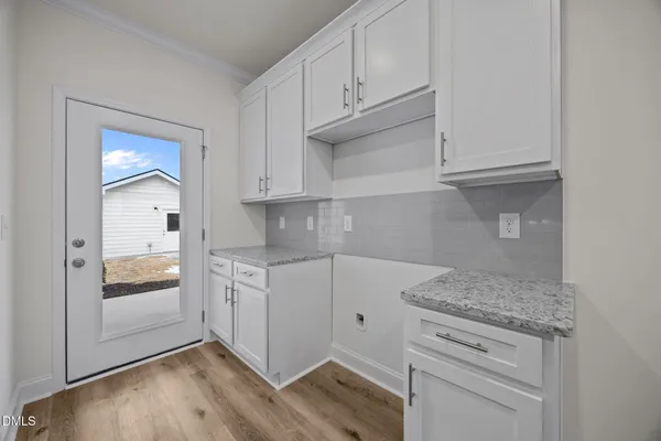 a kitchen with granite countertop white cabinets and white appliances