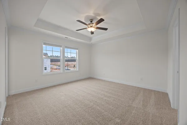 an empty room with windows and ceiling fan