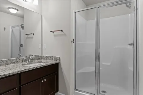 a bathroom with a granite countertop sink and shower